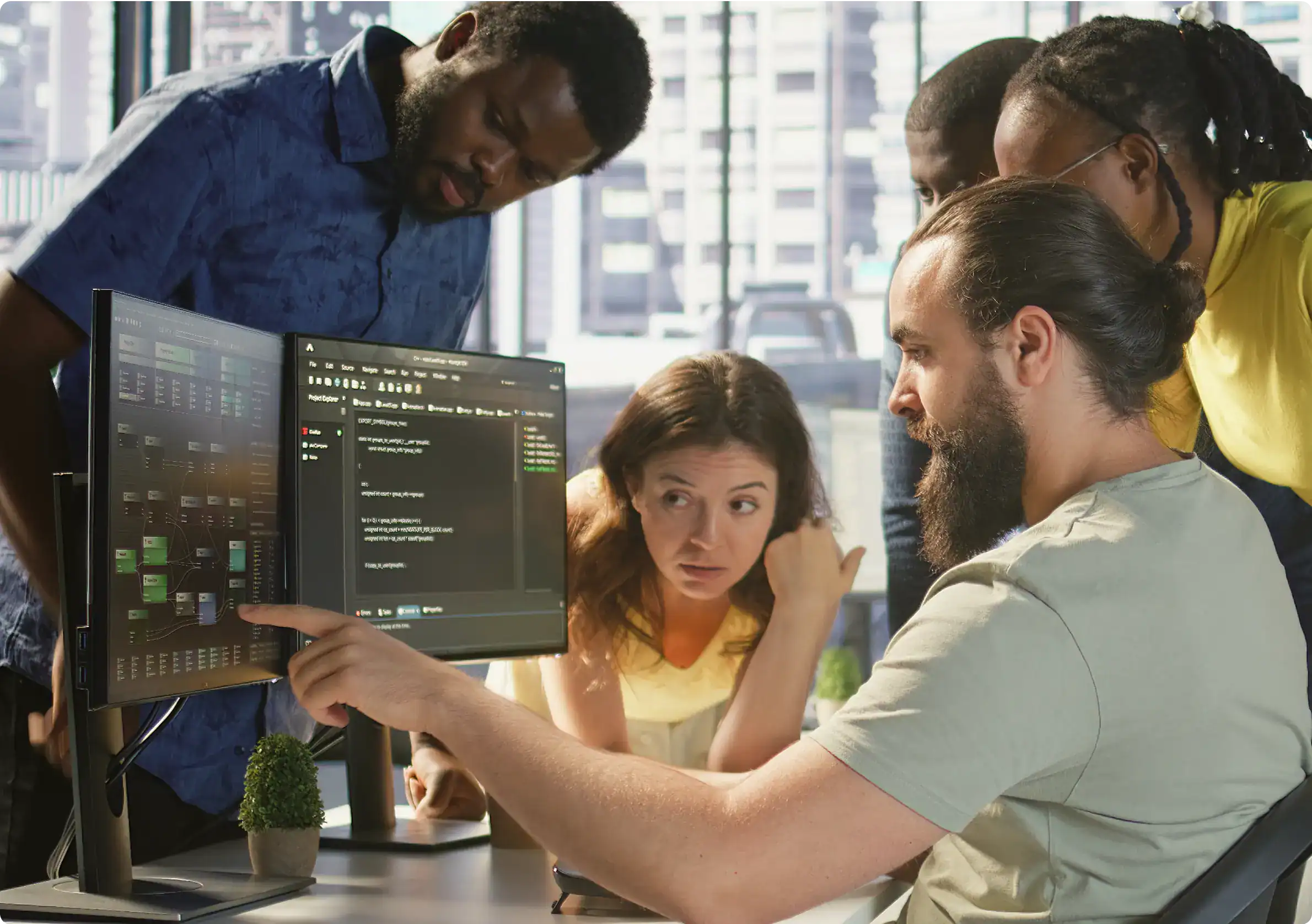 Team analyzing threat data on dual monitors during a security awareness training session, focusing on cyber security awareness and human risk management in a modern workplace setting.