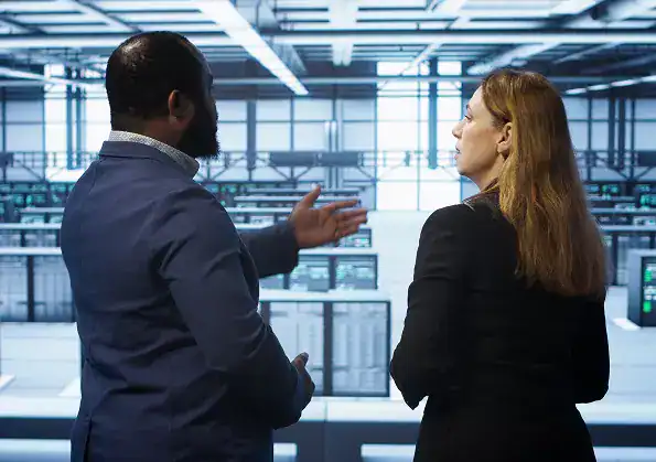Two professionals discuss endpoint protection services in a modern data center.