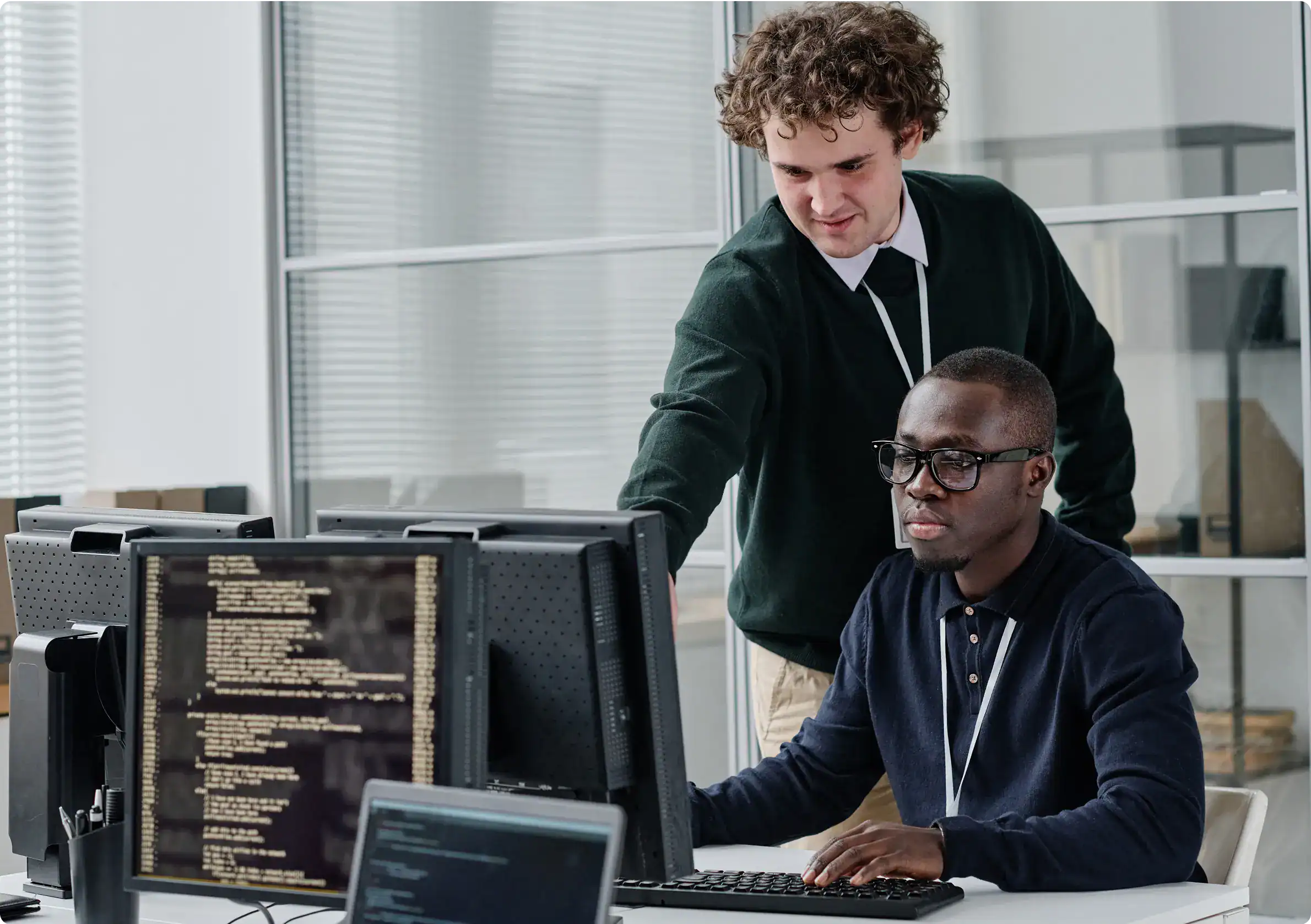 Developers collaborating on secure code implementation as part of DevSecOps services for modern development pipelines